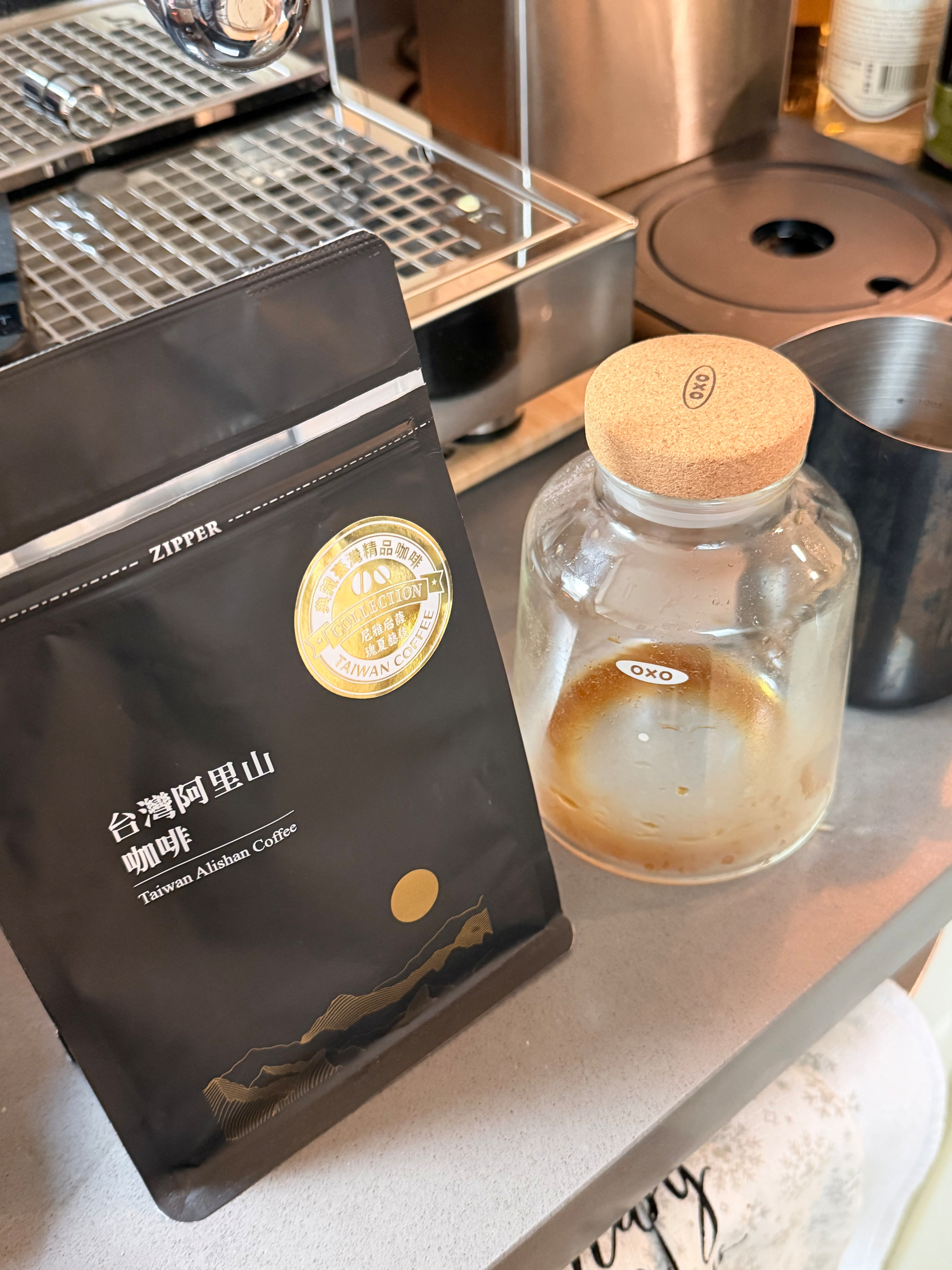Bag of Taiwanese Alishan coffee beans and empty OXO cold brew glass container with remains of coffee concentrate 